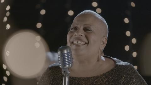 singer with twinkling last in background