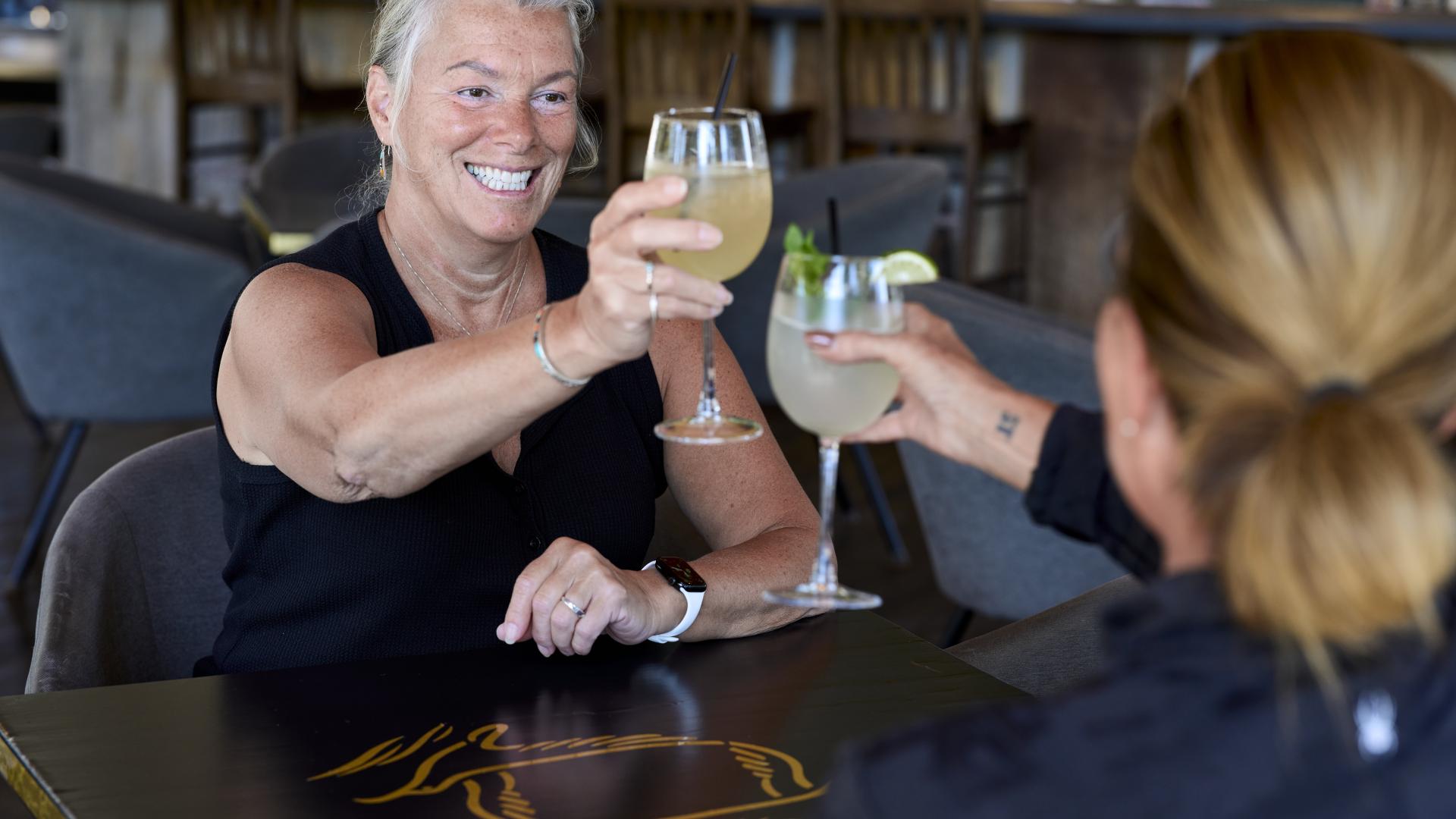 two people cheering at table restaurant