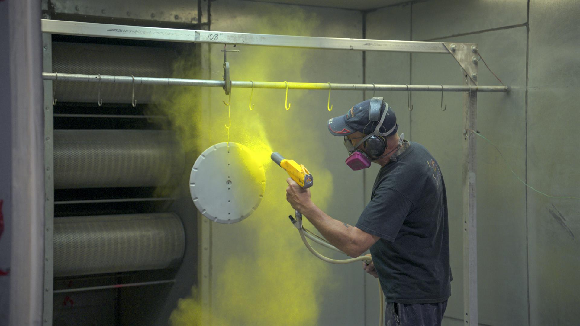 worker spray painting in industrial setting